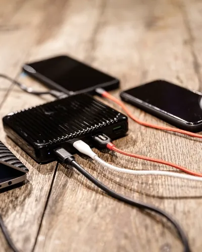 A power bank charging phones on a wooden table